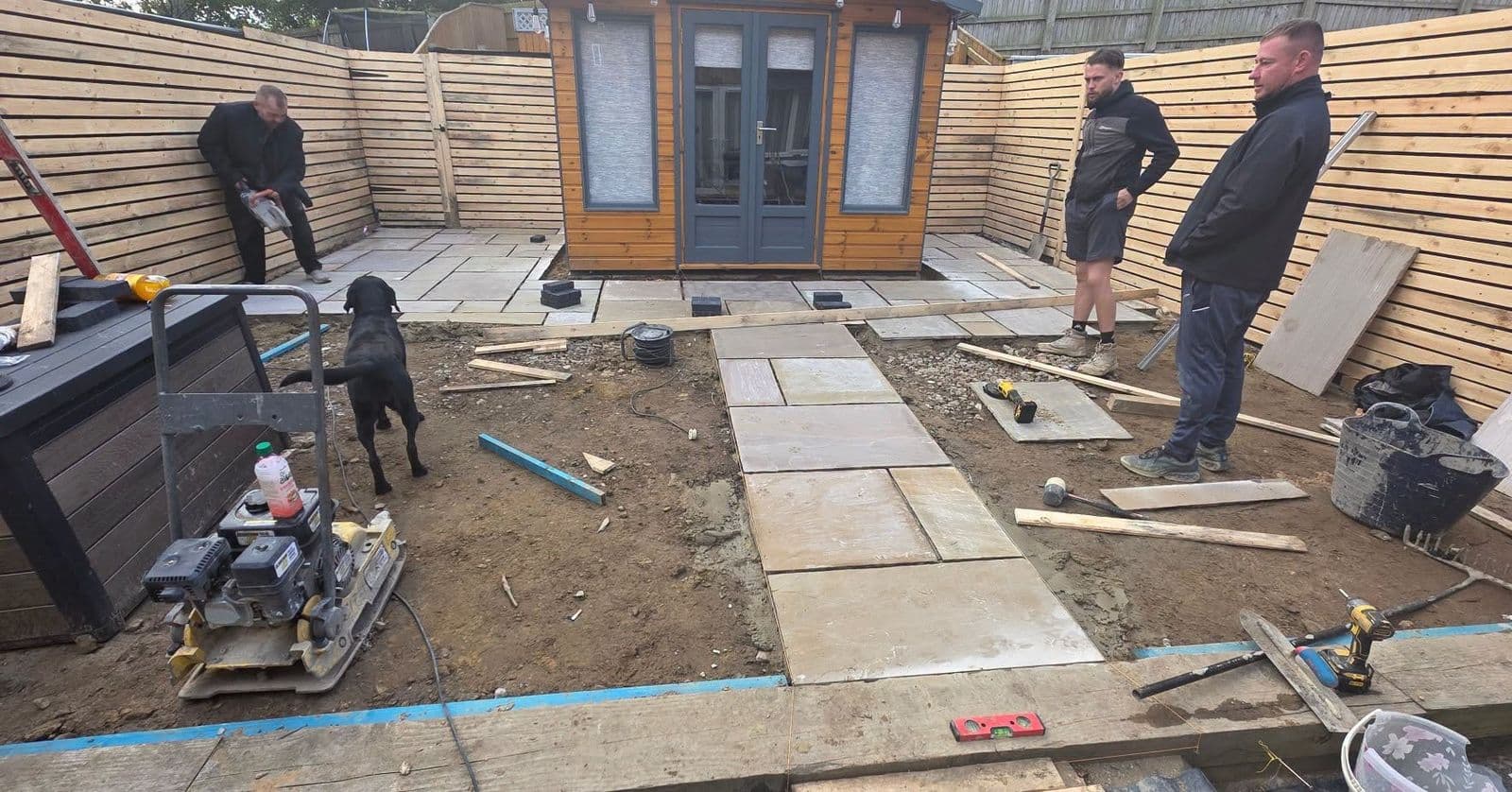 The M&C Landscaping team laying a sandstone patio in a garden in Hebburn