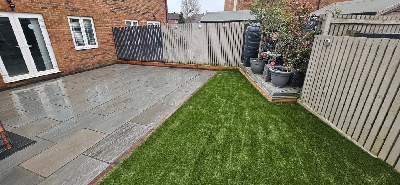 Grey sandstone patio and artificial grass in Jarrow