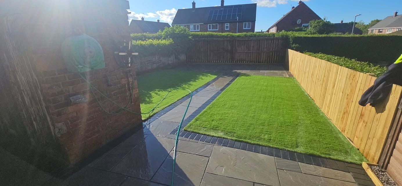 After: Indian sandstone patio and two artificial lawns in Wardley