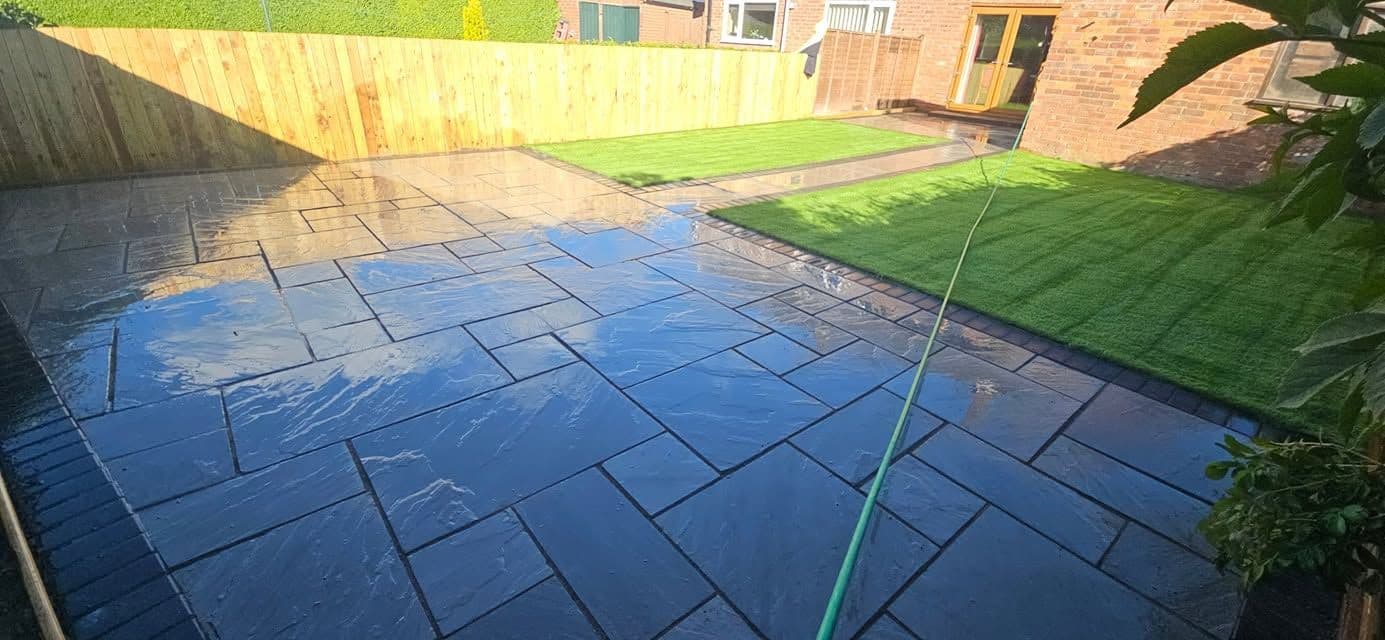 Indian sandstone patio and two artificial lawns in Wardley