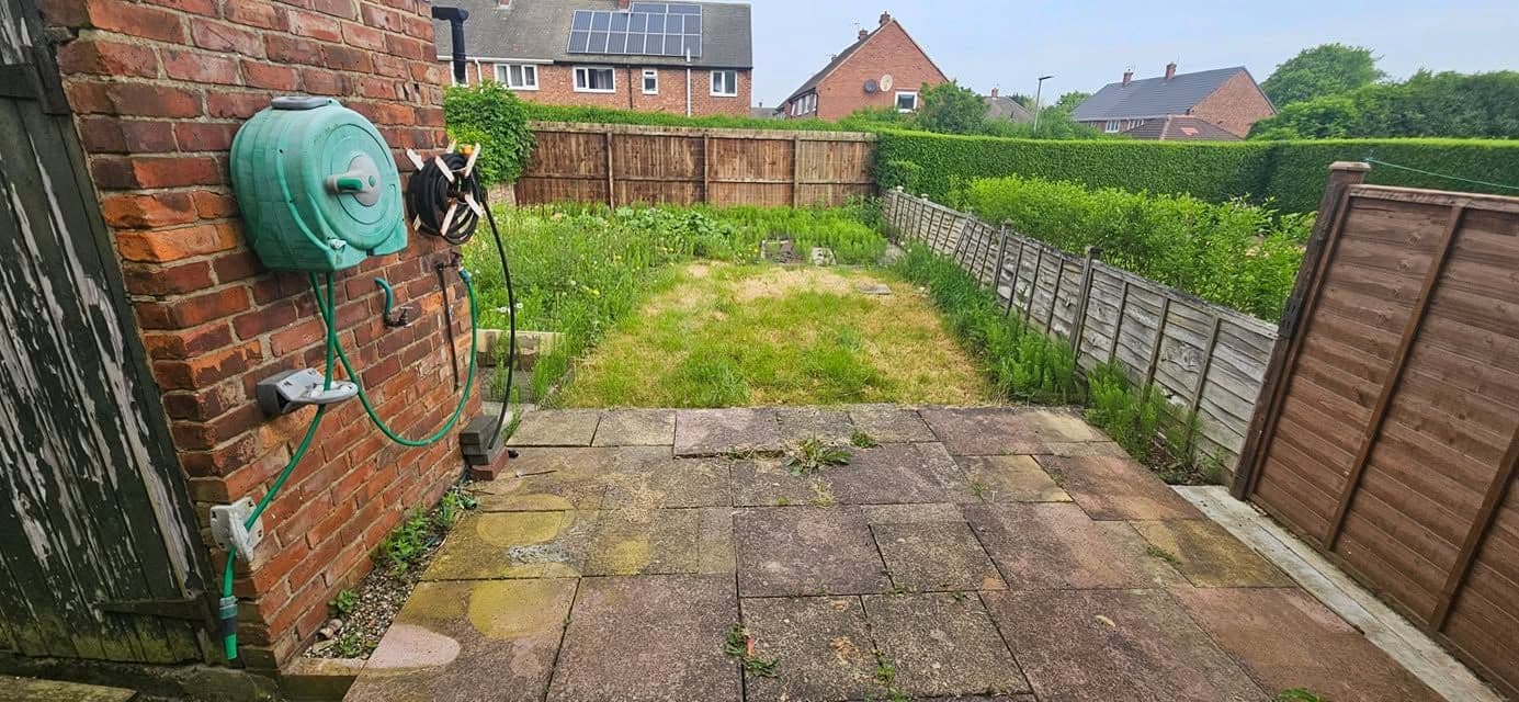 Before: Indian sandstone patio and two artificial lawns in Wardley
