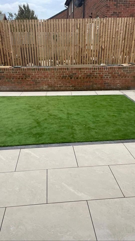 After: White porcelain patio framing an artificial lawn