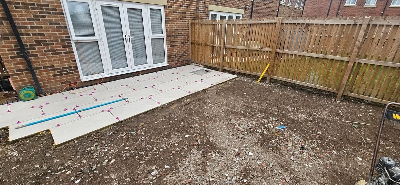 Before: White porcelain patio framing an artificial lawn